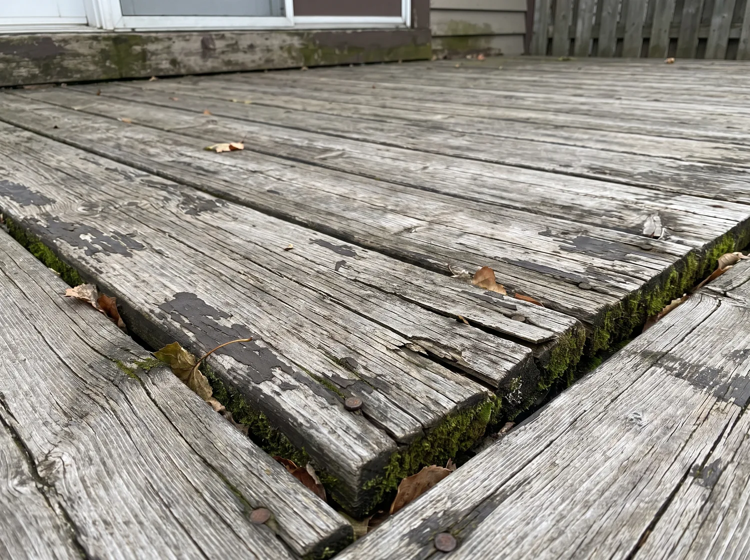 Weathered gray deck with cracked and splintered boards before restoration